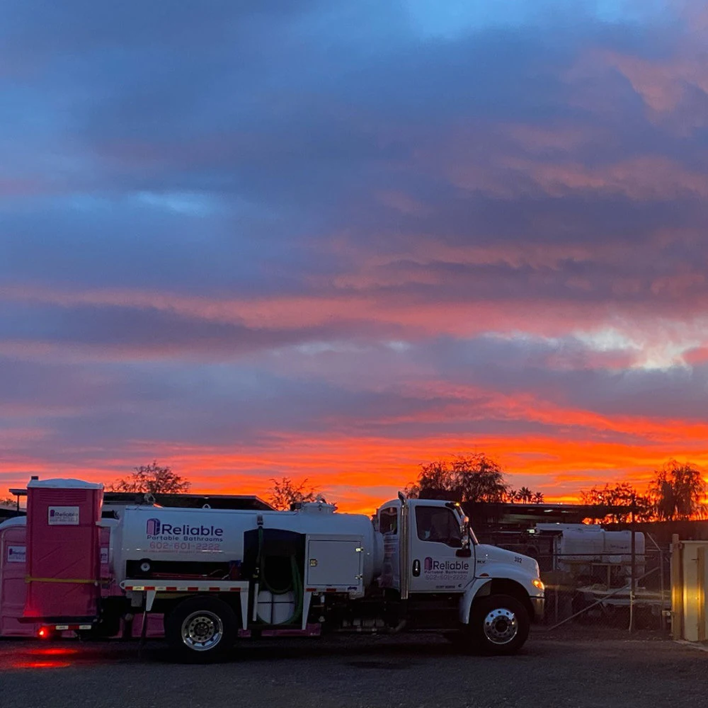 Row of blue portable restrooms on a gravel lot